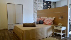 Un dormitorio moderno con cama, mesita de noche y velador.