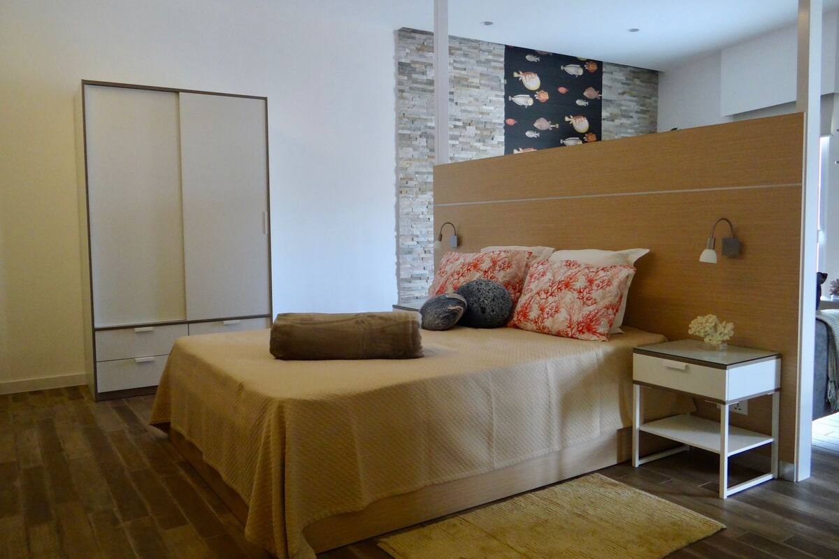A modern bedroom with a bed, bedside table, and a nightstand.