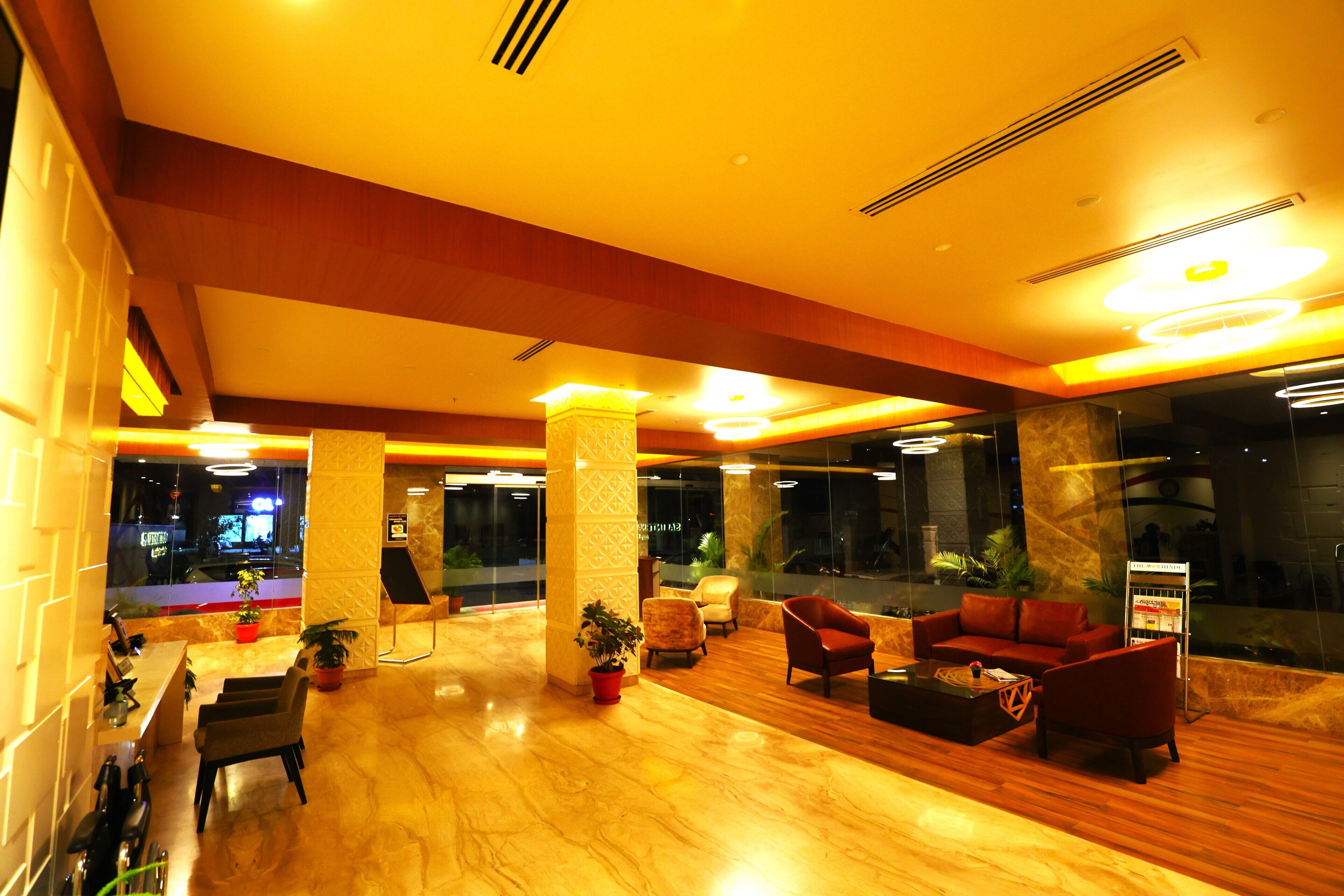 A lobby with a reception desk, seating area, and large windows.
