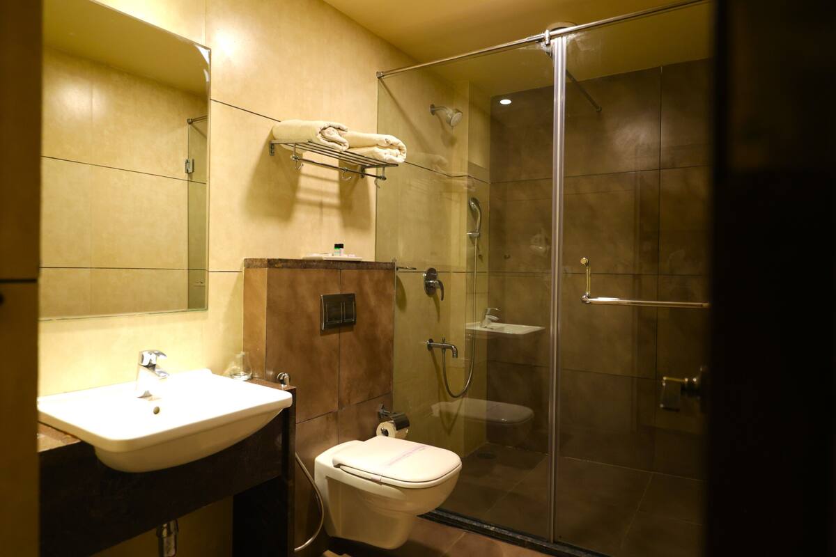 Une salle de bain moderne avec une douche à parois de verre, un lavabo et des toilettes.