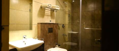 A modern bathroom with a glass-enclosed shower, a sink, and a toilet.