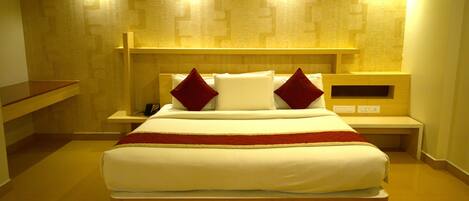 Una habitación de hotel moderna con una cama grande, dos mesitas de noche y un banco empotrado a lo largo de la pared.