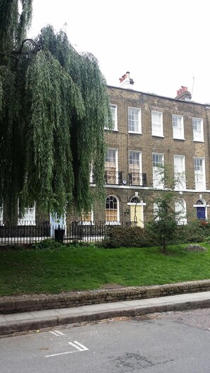 Stunning two-story building with a traditional facade, surrounded by a well-manicured lawn and a secure metal fence.