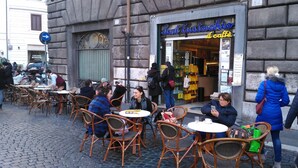 Un café con terraza, fachada de piedra y un letrero que dice "Lantuchio il caffè".