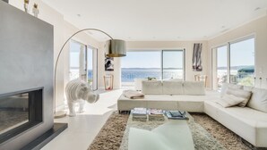 A modern living room with a sofa, a coffee table, and a fireplace.