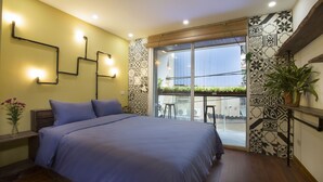 A modern bedroom with a large bed, a window with a view of a balcony, and decorative wall panels.