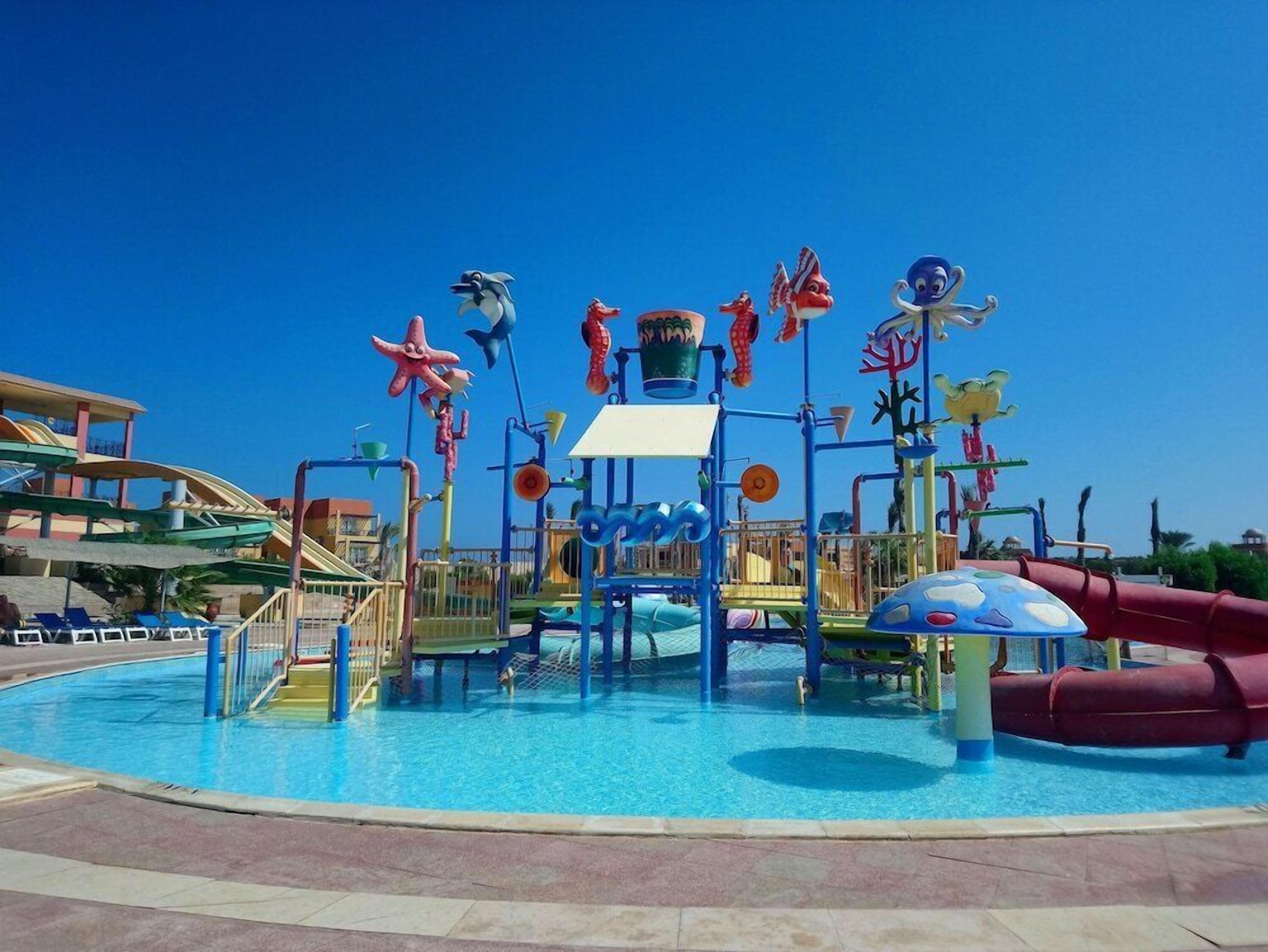 Ein Wasserpark mit einem zentralen Pool, Rutschen und verschiedenen Spielbereichen.