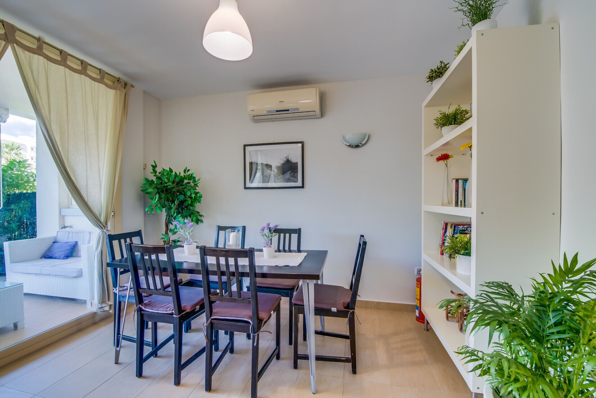 A dining area with a table, chairs, and a bookshelf.