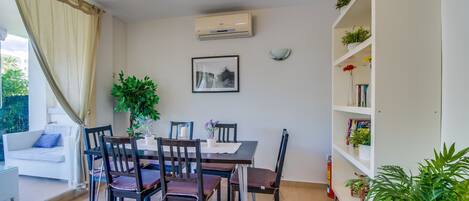 A dining area with a table, chairs, and a bookshelf.