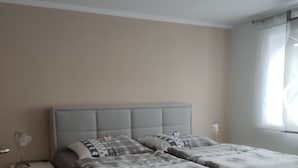 Une chambre à coucher avec un lit, des tables de chevet et un luminaire au plafond.