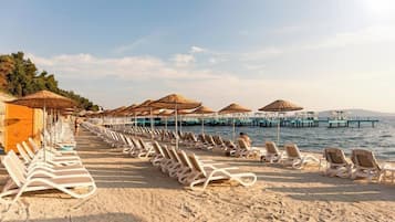 Playa privada, sillas reclinables de playa, sombrillas, toallas de playa