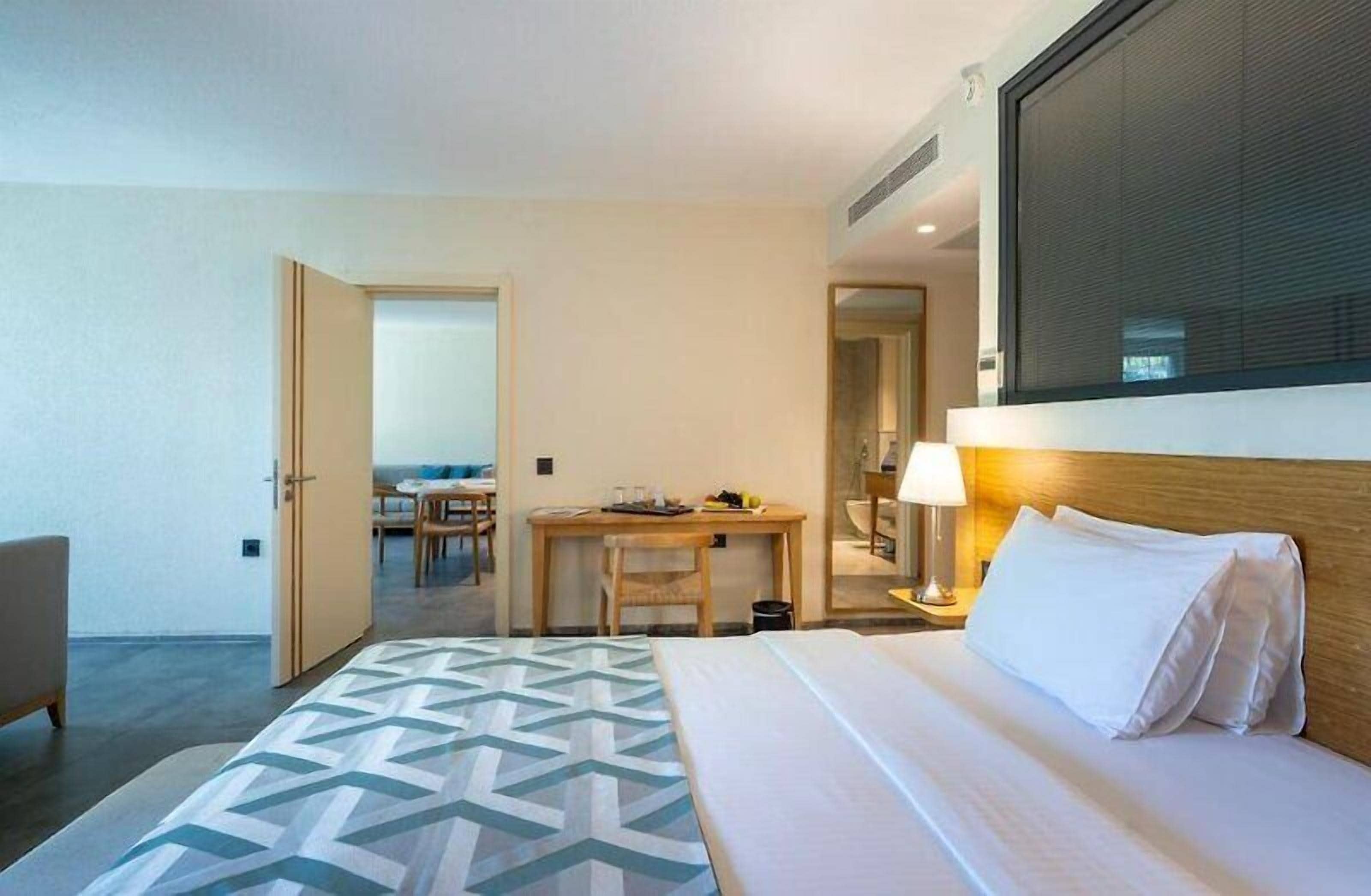 Une chambre d’hôtel avec un lit, un bureau, une chaise et une table.