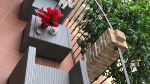 A terrace with wicker furniture and potted plants.