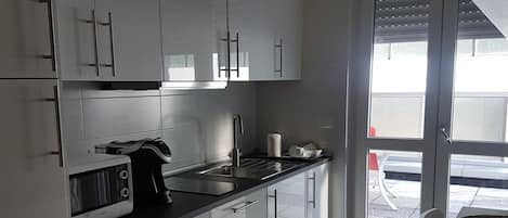 Kylskåp, mikrovågsugn, spishäll och grytor/köksredskap