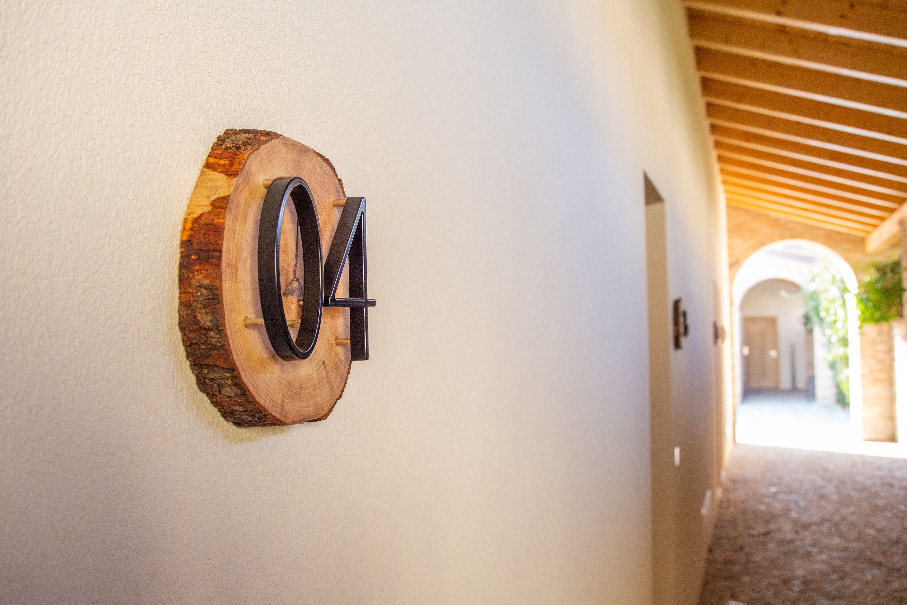 A hallway with a wooden number sign '04' on the wall.