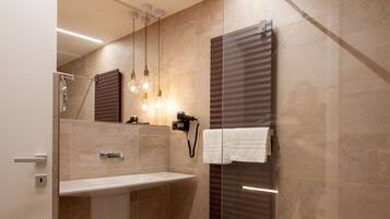 A modern bathroom with a glass shower enclosure, a vanity with a mirror, and a towel rack.