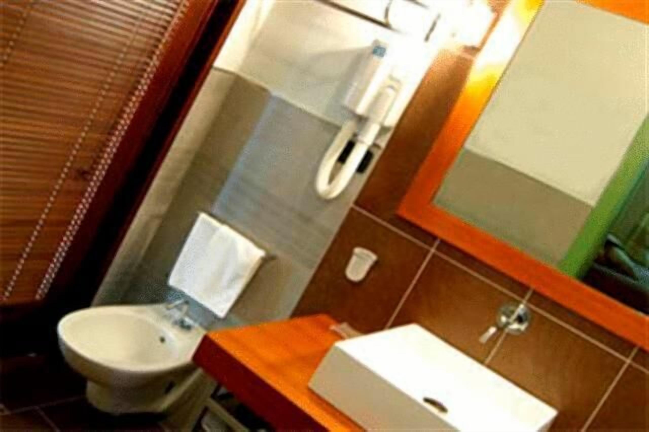 A bathroom with a toilet, bidet, and a mirror.