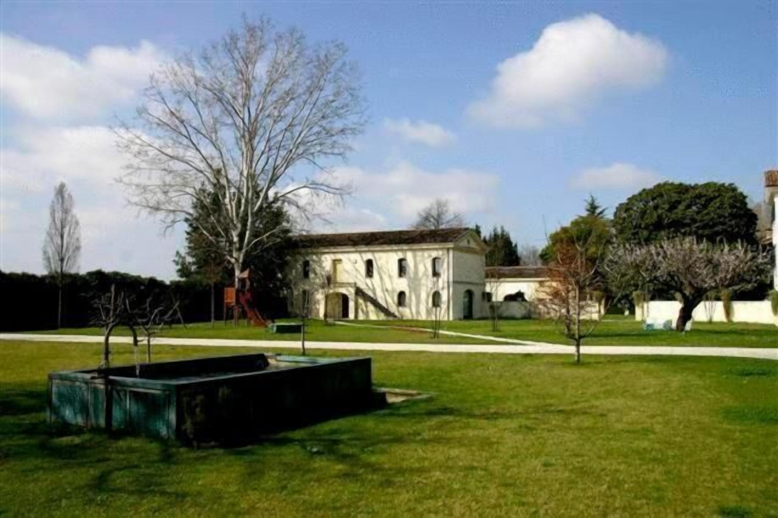 Un edificio con facciata simmetrica, finestre ad arco e un ingresso centrale.