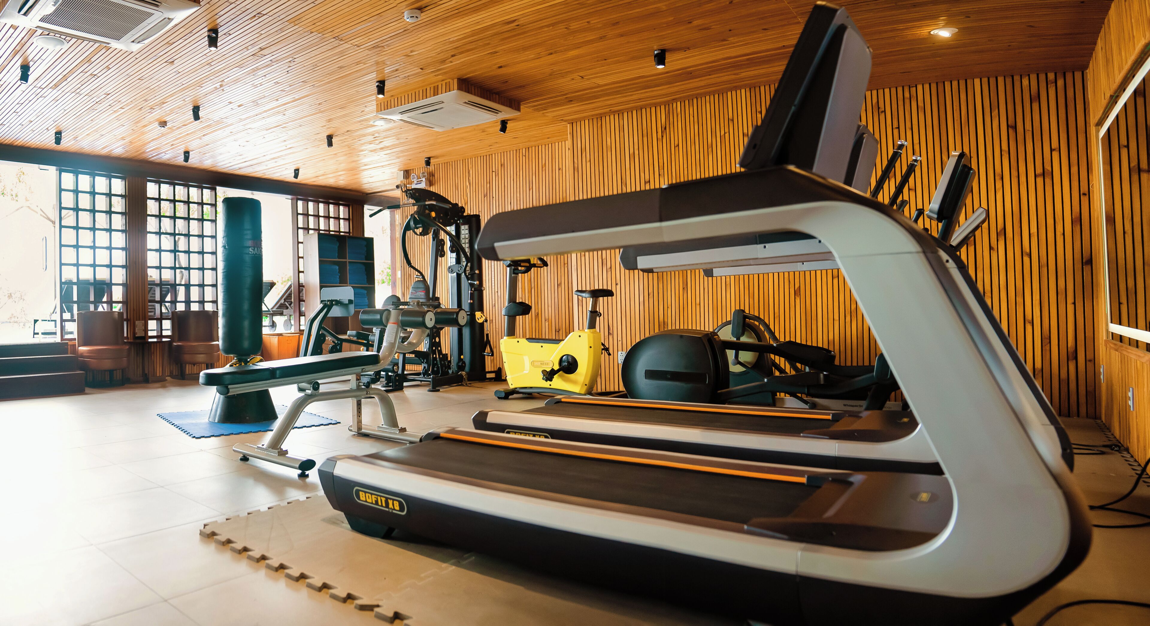 A gym with a treadmill, stationary bike, and weights.