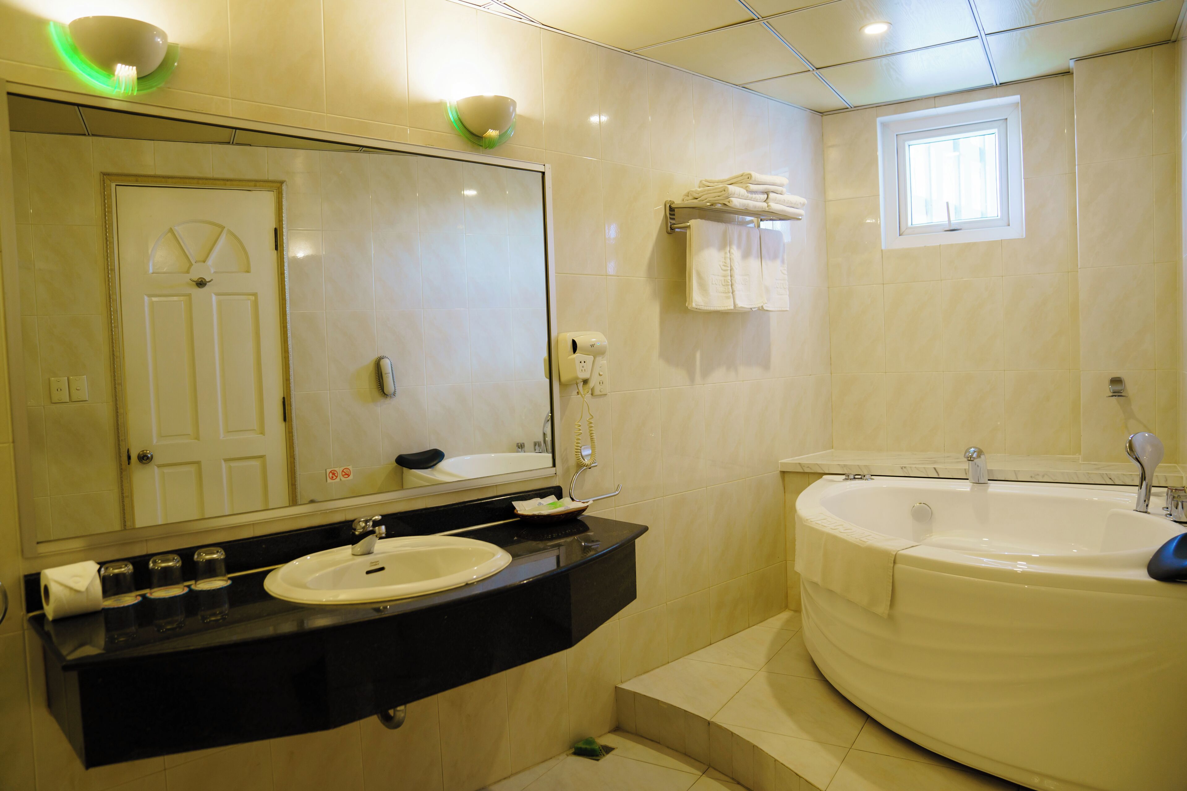 A bathroom with a sink, mirror, towel rack, and bathtub.