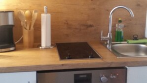 Uma cozinha com lava-louças, pia e armários de madeira.