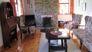 Un salon chaleureux avec une cheminée en pierre, des meubles en bois et un téléviseur.