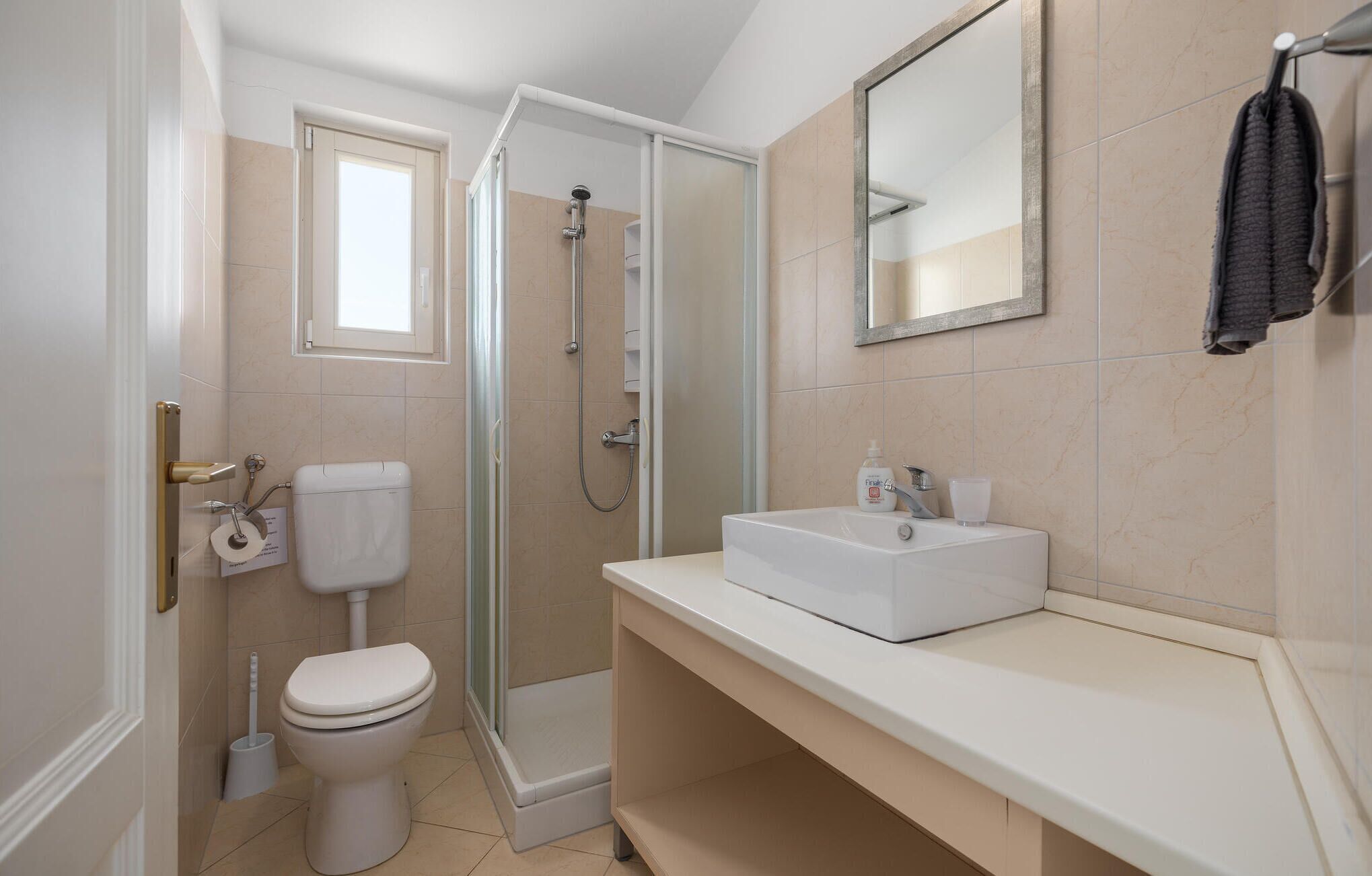 Un baño moderno con inodoro, ducha y lavamanos.