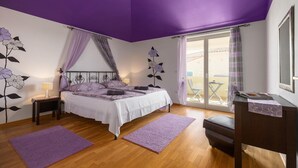 Ein Schlafzimmer mit Bett, Nachttisch, Kommode und einem Fenster mit Ausblick.