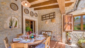 Un comedor rústico con paredes de piedra, muebles de madera y una chimenea de piedra.