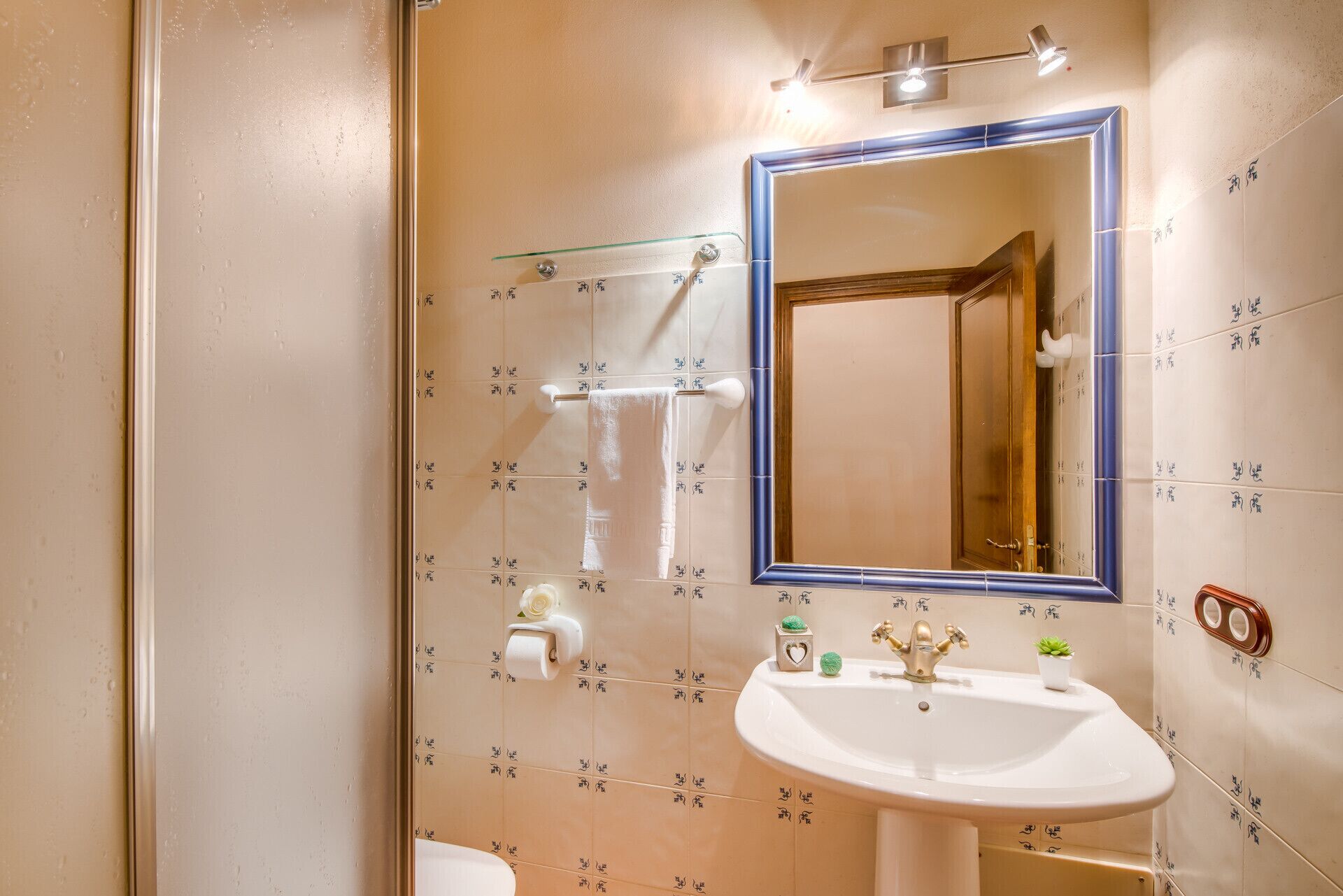 A bathroom with a sink, mirror, and shower.