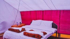 A hotel room with a bed, a nightstand, and a red carpeted floor. - Tsomoriri Camp And Resort (Leh)