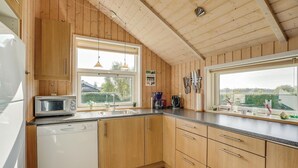 A kitchen with wooden cabinets, a microwave, a coffee maker, and a sink. - Gorgeous home in Sydals with sauna (Sydals)