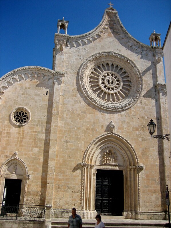 A historic building with a large circular window, a bell tower, and a detailed facade.