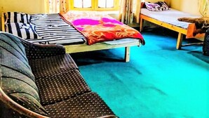 A room with a bed, a sofa, and a chair. - Ibex Guest House (Leh)