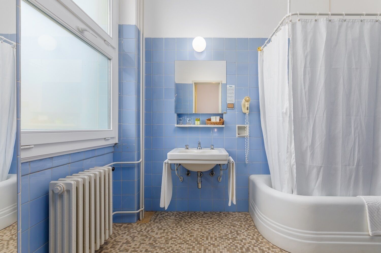 Een badkamer met een wit bad, een wastafel, een spiegel en een douchegordijn.