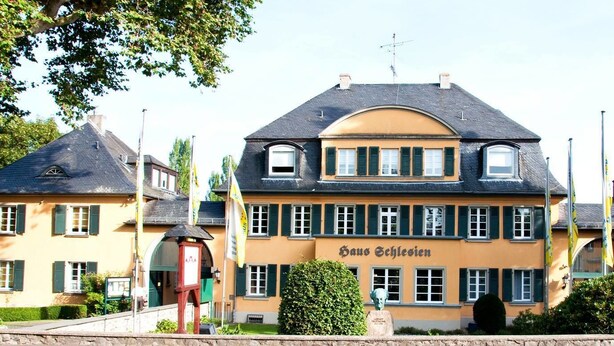 Um edifício de dois andares com uma placa que diz "Haus Schlesien".
