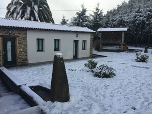 Un bâtiment à la façade en pierre, doté de nombreuses fenêtres et dont le toit est recouvert de neige.