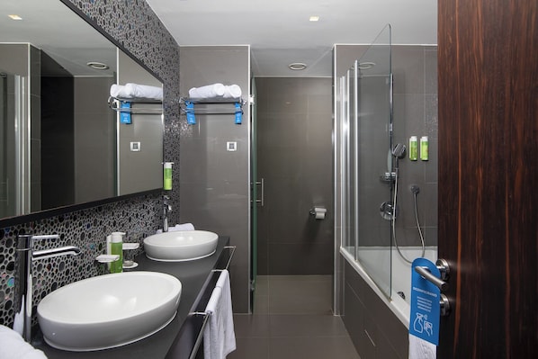 A modern bathroom with two sinks, a large mirror, and a glass-enclosed shower. - Brijuni Hotel Istra (Pula)