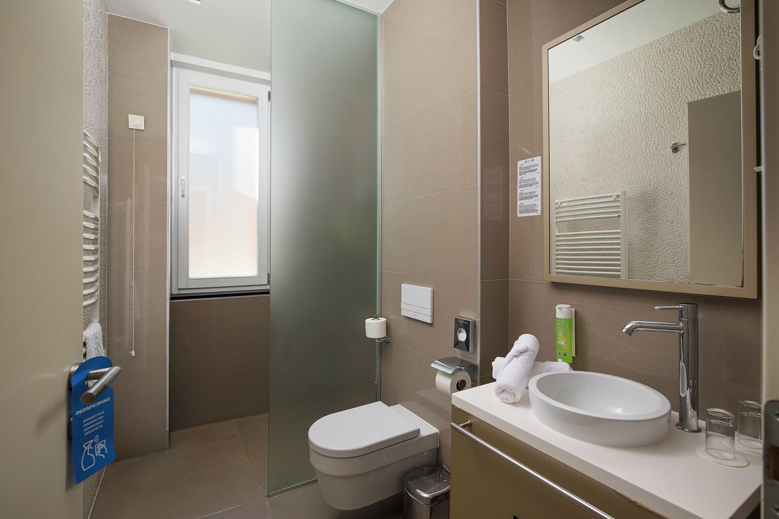 A modern bathroom with a toilet, sink, and shower.