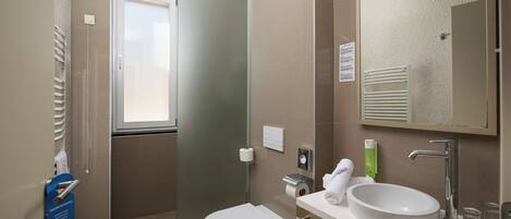 A modern bathroom with a toilet, sink, and shower.