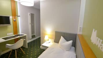 Une chambre d’hôtel comprenant un lit, un bureau avec une chaise, une télévision et une douche.