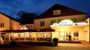 A hotel with a restaurant named "Hotel Restaurant Valdesruh" featuring outdoor seating with umbrellas. - Hotel Restaurant Waldesruh (Emstek)