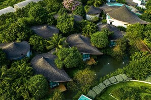 A resort with multiple bungalow-style buildings surrounded by lush greenery and a central water body. - Na Tree Tara Riverside Resort Amphawa Damnoensaduak (Bang Khonthi)