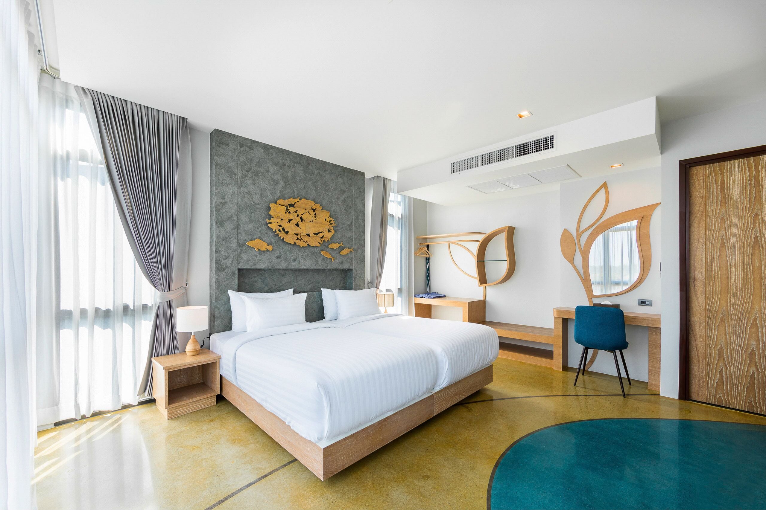 Una habitación de hotel moderna con una cama grande, un escritorio y una silla.