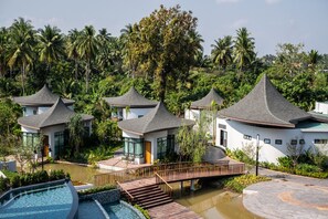 A resort with multiple bungalow-style buildings, a swimming pool, and a bridge connecting the structures. - Na Tree Tara Riverside Resort Amphawa Damnoensaduak (Bang Khonthi)