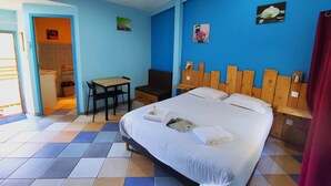 A hotel room with a bed, a desk, a chair, and a small bathroom. - Sarlat double room (VITRAC)