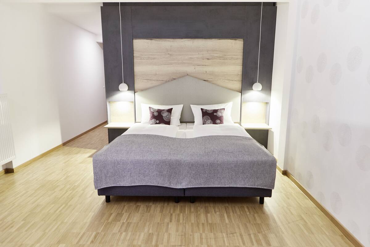 A modern bedroom with a large bed, two bedside tables, and a headboard.