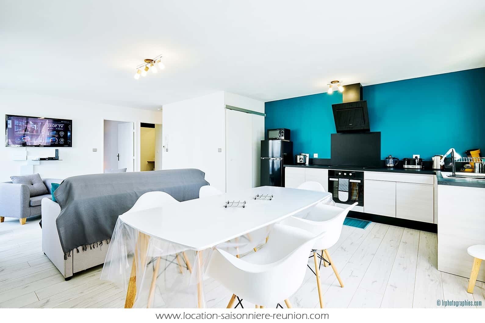 Un appartement moderne comprenant un coin repas, une kitchenette et un salon.