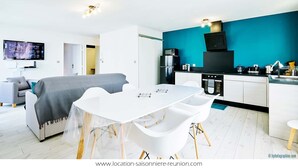 Een modern appartement met een eethoek, kitchenette en woonkamer.