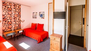 A room with a bed, a desk, a television, and a wardrobe. - Divisible studio for 3, near shops and slopes, free parking, balcony (Bellentre)